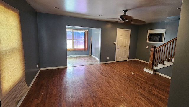 foyer featuring visible vents, wood finished floors, stairway, baseboards, and ceiling fan