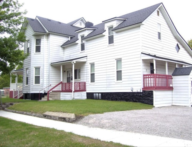 view of front of house featuring a porch, a front lawn, and roof with shingles