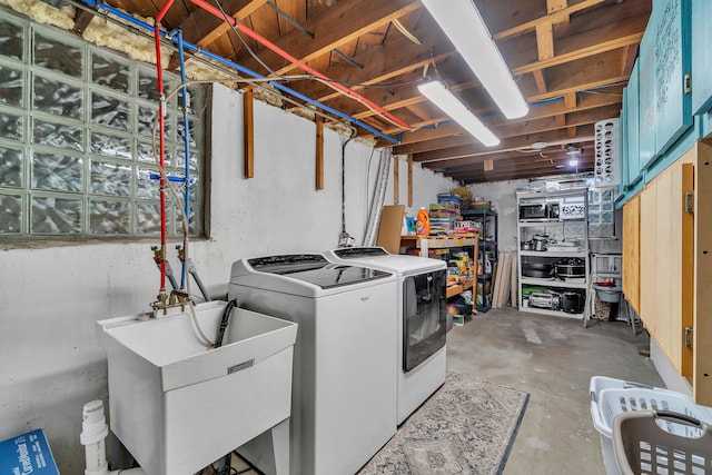 clothes washing area with a sink, laundry area, and washer and clothes dryer