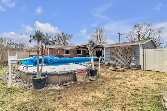 exterior space featuring a lawn, fence, a fenced in pool, and an outdoor fire pit