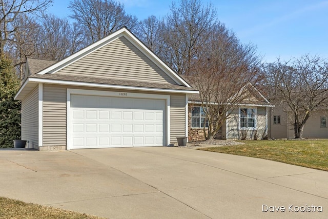 ranch-style house featuring concrete driveway, a garage, a front lawn, and roof with shingles