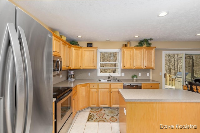 kitchen featuring tasteful backsplash, light countertops, light tile patterned floors, stainless steel appliances, and a sink