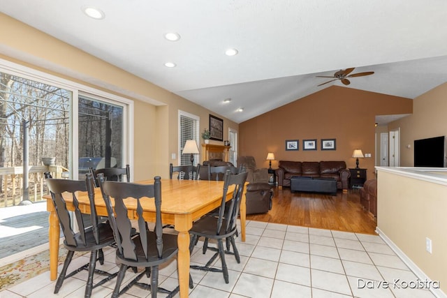 dining room with ceiling fan, vaulted ceiling, light tile patterned floors, recessed lighting, and a fireplace