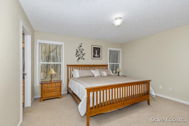 carpeted bedroom featuring baseboards and a textured ceiling