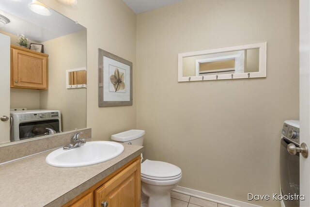 bathroom featuring vanity, washer / dryer, toilet, and tile patterned floors