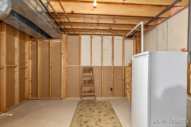 unfinished basement featuring refrigerator