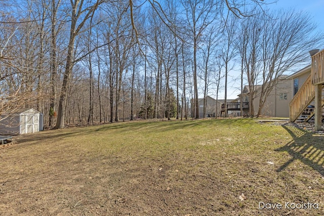 view of yard with stairway, a storage shed, and an outdoor structure