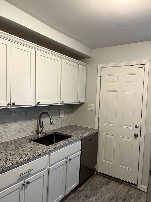 kitchen featuring tasteful backsplash, dishwasher, stone counters, white cabinets, and a sink