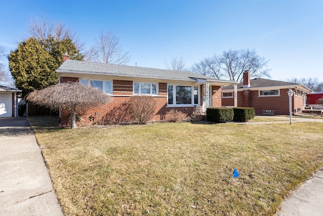 ranch-style house featuring a front yard, a chimney, concrete driveway, a garage, and brick siding