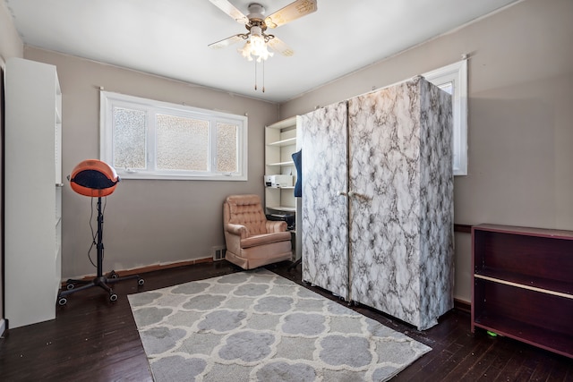 sitting room featuring hardwood / wood-style floors, baseboards, and ceiling fan