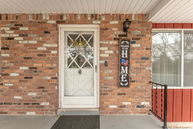 view of exterior entry featuring brick siding