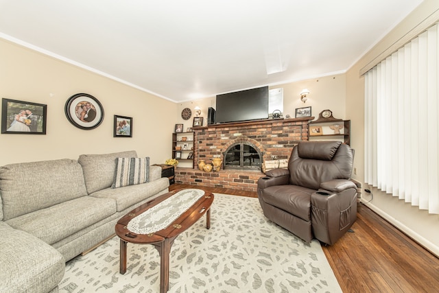 living area featuring a brick fireplace, crown molding, and wood finished floors