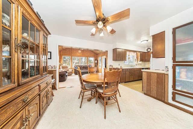 dining room featuring light carpet, a healthy amount of sunlight, and a ceiling fan