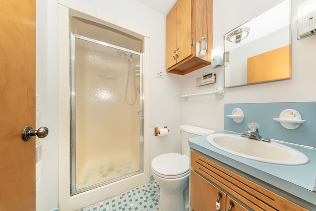 bathroom with a shower stall, toilet, and vanity