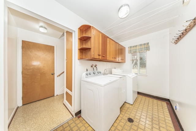 laundry room featuring baseboards, cabinet space, separate washer and dryer, and light floors