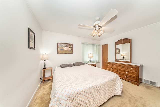 bedroom featuring visible vents, light colored carpet, baseboards, and ceiling fan