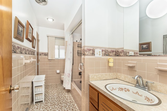 bathroom featuring visible vents, a wainscoted wall, vanity, tile walls, and shower / bathtub combination with curtain