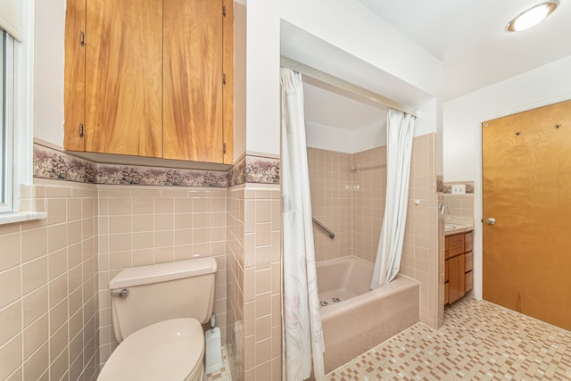 full bathroom featuring a wainscoted wall, toilet, shower / tub combo with curtain, tile walls, and vanity