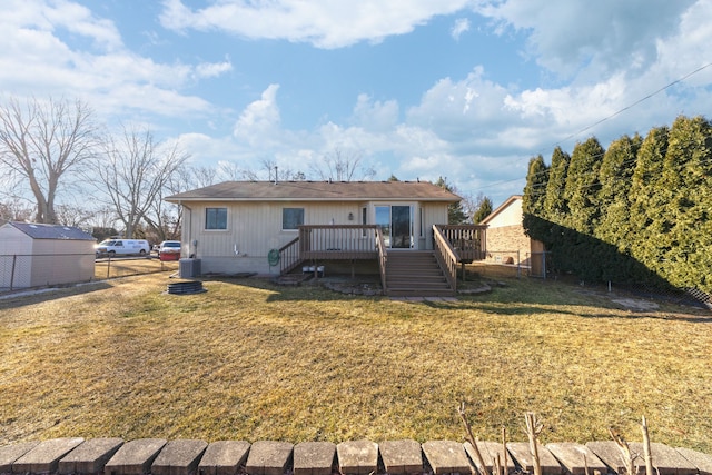 back of property featuring a yard, stairway, a deck, and fence