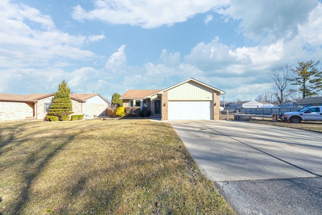 view of front of property featuring a front yard, fence, concrete driveway, a garage, and brick siding