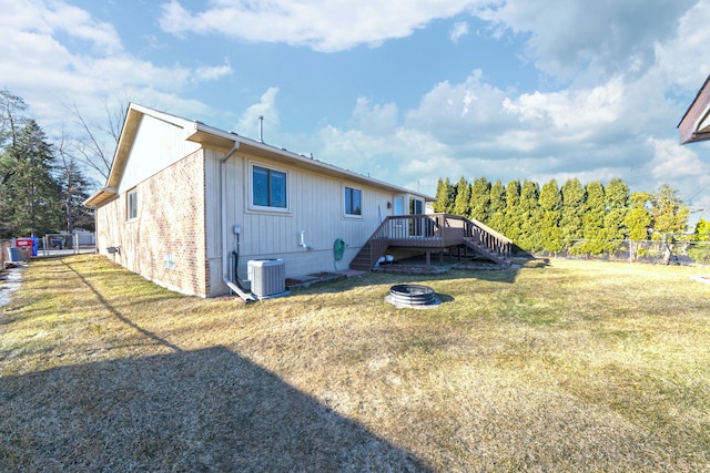 rear view of property with stairway, central air condition unit, a yard, and fence