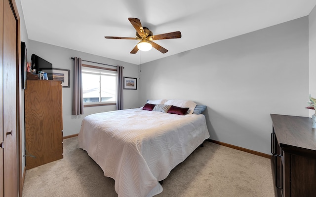 carpeted bedroom with ceiling fan and baseboards