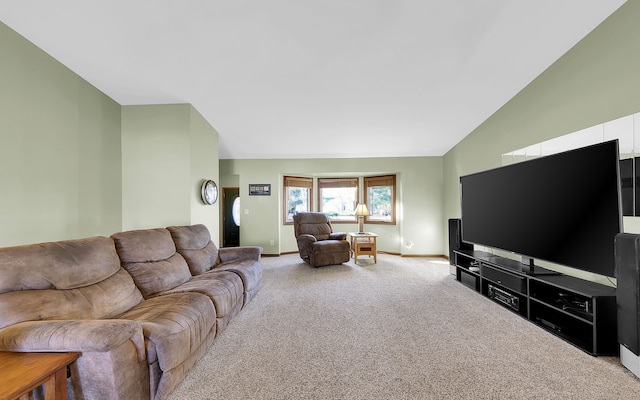 carpeted living room with lofted ceiling and baseboards