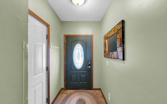 entryway with baseboards and carpet floors