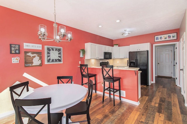 dining room with dark wood finished floors, recessed lighting, baseboards, and a chandelier