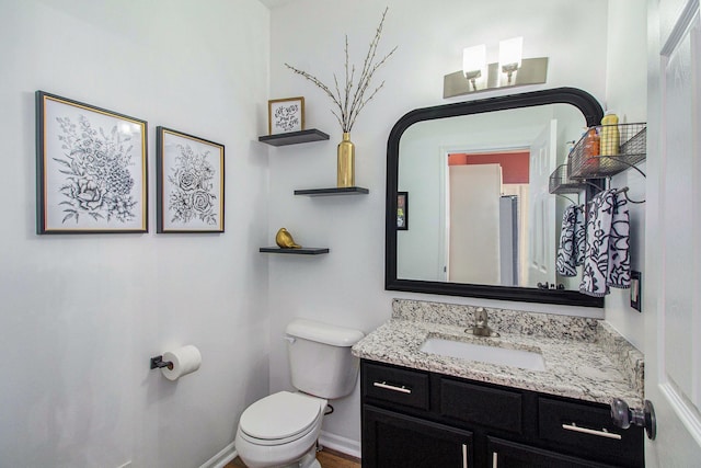 bathroom with vanity, toilet, and baseboards