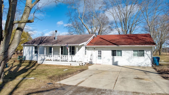 ranch-style home featuring a porch, driveway, and a front yard