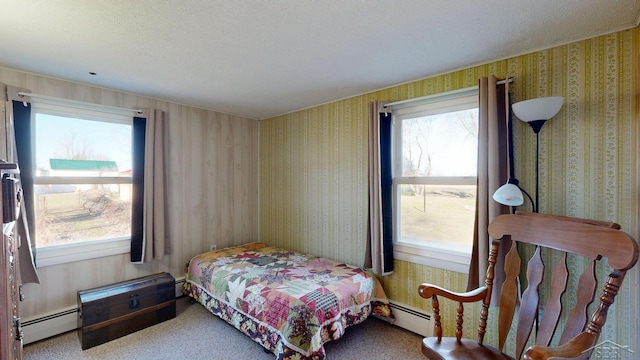 bedroom with wallpapered walls, a baseboard heating unit, and a textured ceiling