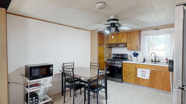 kitchen with ventilation hood, brown cabinetry, a sink, stainless steel appliances, and light countertops