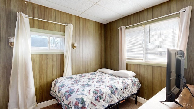 bedroom with wood walls and a paneled ceiling