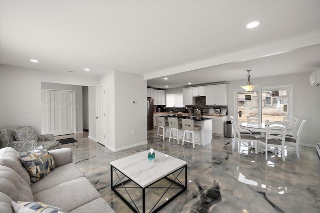 living area featuring recessed lighting, baseboards, and a wall mounted air conditioner