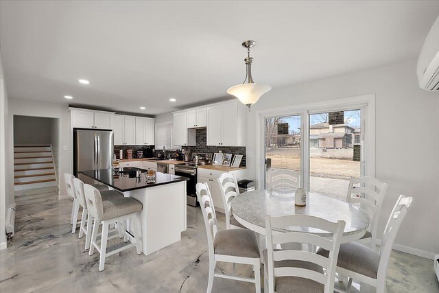 dining room with stairway, baseboards, recessed lighting, concrete flooring, and a wall mounted air conditioner