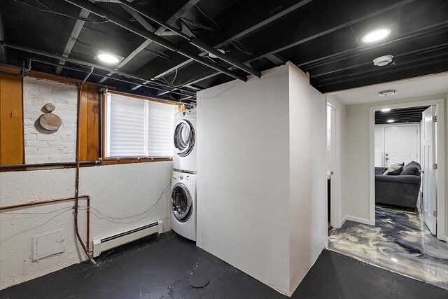 washroom with laundry area, stacked washer and dryer, and baseboard heating