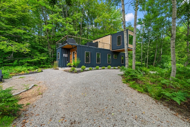 contemporary house featuring gravel driveway and board and batten siding