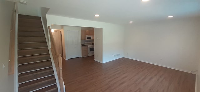 empty room with recessed lighting, visible vents, dark wood-style floors, and stairs