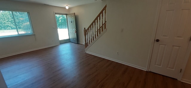 entrance foyer with baseboards, dark wood finished floors, and stairs