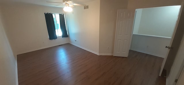 spare room featuring dark wood-style floors, visible vents, baseboards, and ceiling fan