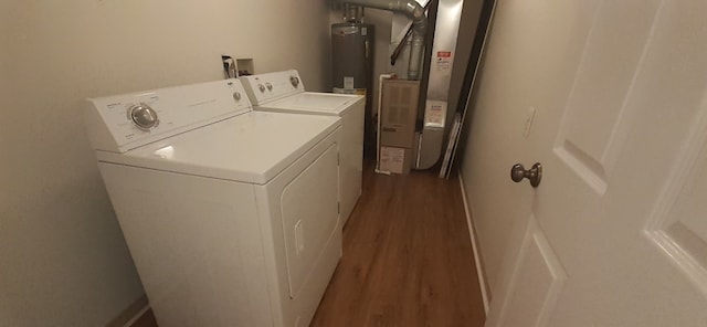 washroom featuring heating unit, wood finished floors, washing machine and dryer, water heater, and laundry area