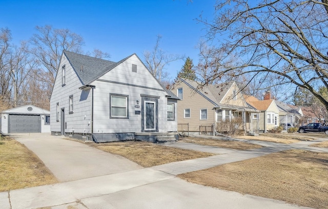 bungalow with an outbuilding, driveway, entry steps, a detached garage, and a residential view