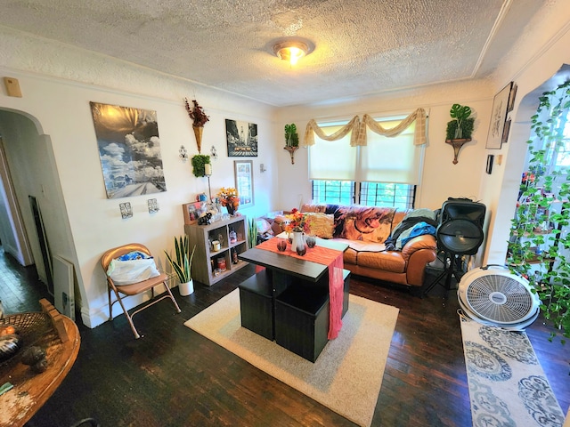 living area featuring arched walkways, a textured ceiling, and wood-type flooring