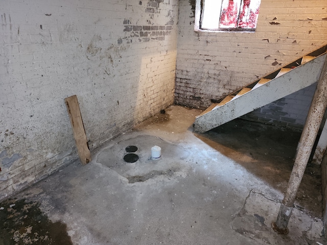 bathroom with concrete floors and brick wall