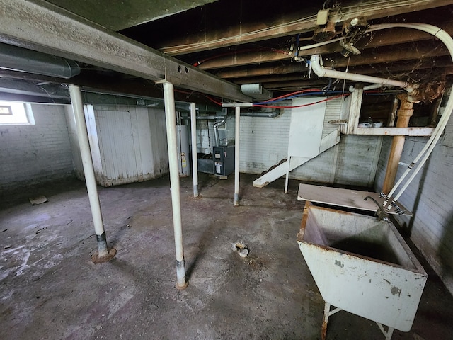 basement with water heater, heating unit, and a sink