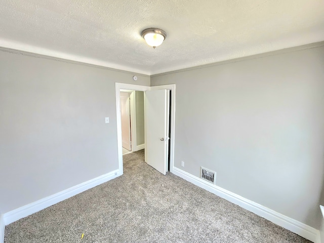 empty room with visible vents, baseboards, a textured ceiling, and carpet flooring