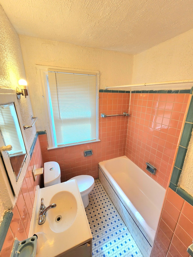 full bath featuring toilet, a textured ceiling, a textured wall, and a sink