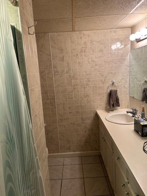 full bath with tile patterned flooring, tile walls, a shower with curtain, and vanity