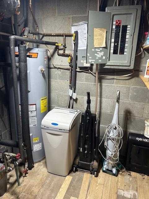 utility room featuring electric panel and electric water heater